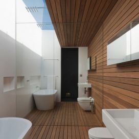 Moderní koupelna s dřevěnou podlahou a obklady ze dřeva Monika Nová