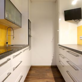Lakovaná bílá kuchyň s projasňujícím žlutým lakovaným sklem